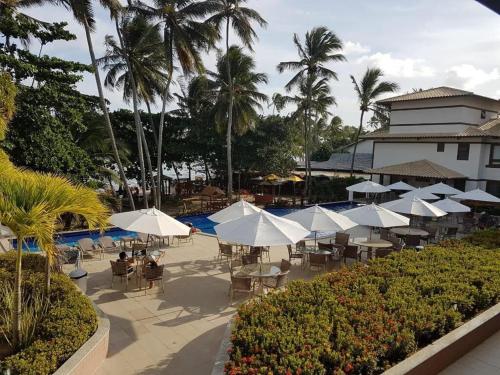 a group of tables and umbrellas at a resort at Cancún Praia do Forte in Mata de Sao Joao