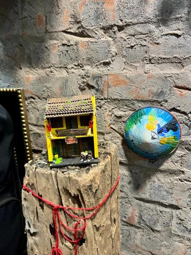 a small toy house sitting on a brick wall at Rik Homestay in Hanoi