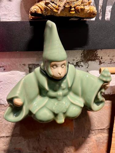 a green gnome sitting on top of a shelf at Rik Homestay in Hanoi