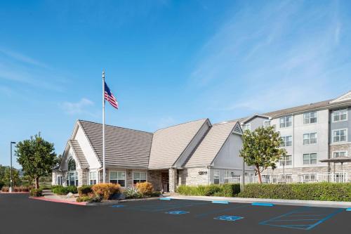 a building with an american flag in a parking lot at Residence Inn San Diego Rancho Bernardo Scripps Poway in Sabre Springs