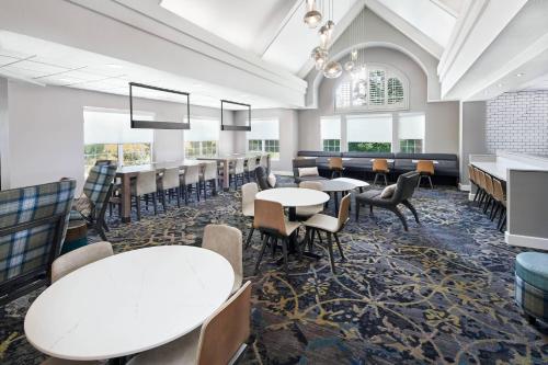 a dining room with tables and chairs and windows at Residence Inn San Diego Rancho Bernardo Scripps Poway in Sabre Springs