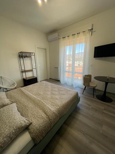 a bedroom with a bed and a table and a window at Donna Giovanna Guest House in Cosenza