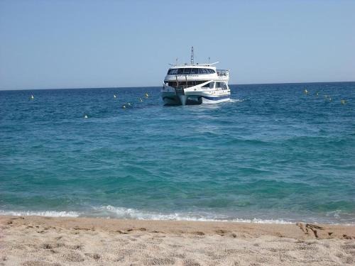 a boat in the water next to a beach at Estudio Paz in Lloret de Mar