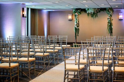 a row of chairs in a room with plants at San Francisco Airport Marriott Waterfront in Burlingame