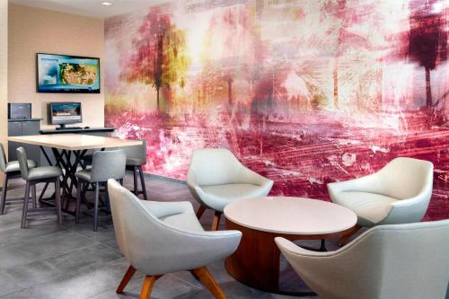 a restaurant with tables and chairs and a painting on the wall at Courtyard by Marriott LaGrange in La Grange