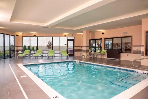 una piscina in un hotel con sedie e tavoli verdi di Courtyard by Marriott Cleveland Elyria a Elyria