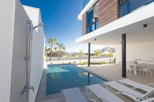 an external view of a house with a swimming pool at Aqua Pearl Villas in Protaras