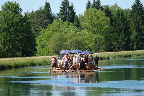 a group of people on a raft in a river at Hotel Waldgasthof Buchenhain in Baierbrunn