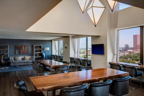 a dining room with tables and chairs and a large window at JW Marriott Houston by the Galleria in Houston