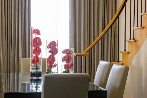a dining room with a glass table with red flowers at JW Marriott Houston by the Galleria in Houston