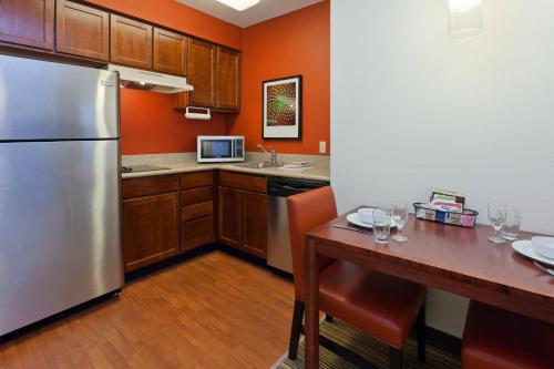 a kitchen with a stainless steel refrigerator and a wooden table at Residence Inn Indianapolis Carmel in Carmel