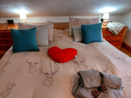a bed with a red heart on top of it at mansarda roulette in Saint Vincent
