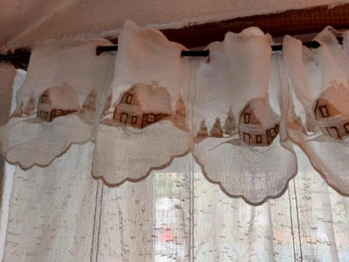 a white curtain with houses on it on a window at mansarda roulette in Saint Vincent