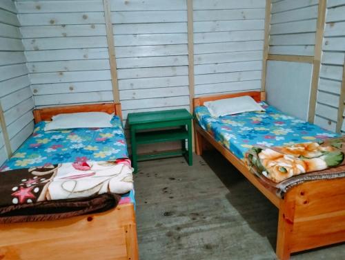 a room with two beds and a green stool at Loseng Farm Stay in Rupa