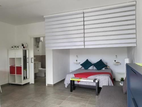 a bedroom with a bed with blue pillows at Marga STUDIO H10 in Arona