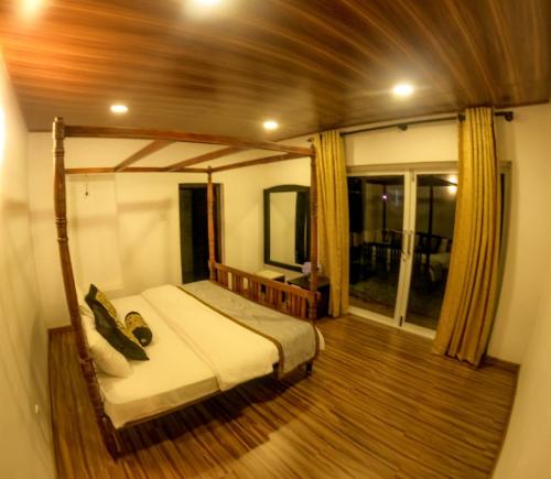 a bedroom with a bed and a wooden floor at Hotel Grand Sun Inn in Nuwara Eliya