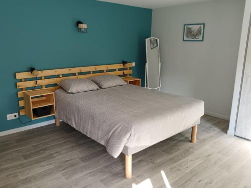 une chambre avec un lit et un mur bleu dans l'établissement Gîte du Tilleul, à Gap