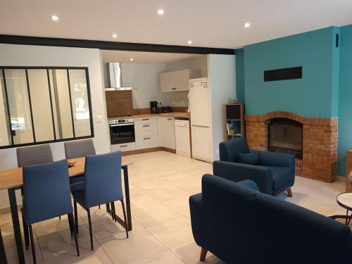 un salon avec une table et des chaises et une cheminée dans l'établissement Gîte du Tilleul, à Gap