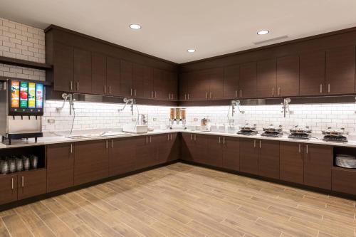 a large kitchen with brown cabinets and white appliances at Residence Inn by Marriott Indianapolis South/Greenwood in Indianapolis
