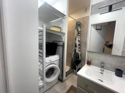 une salle de bain avec une machine à laver et un lavabo dans l'établissement Ty Logis, à Vannes