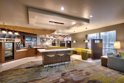 a large kitchen with a bar and a living room at Courtyard by Marriott Charlotte Airport LoSo in Charlotte