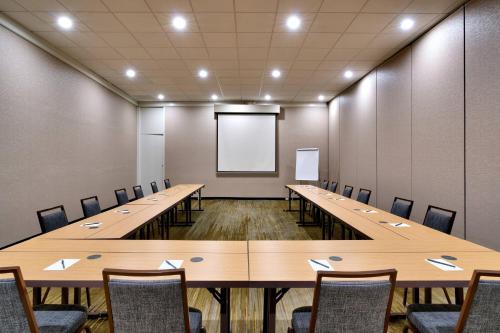 a conference room with tables and chairs and a whiteboard at Courtyard by Marriott Charlotte Airport LoSo in Charlotte