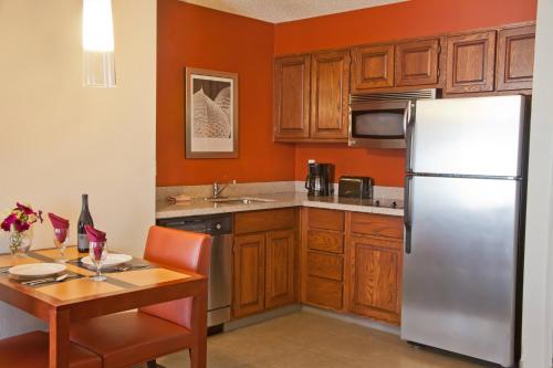 a kitchen with wooden cabinets and a stainless steel refrigerator at Residence Inn Eugene Springfield in Eugene