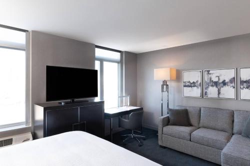a hotel room with a bed and a tv and a couch at Residence Inn Boston Downtown/South End in Boston