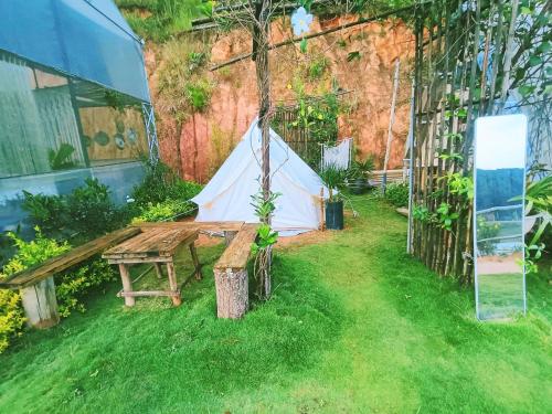 a tent and a wooden table in a yard at Amikaje Farm in Xuan An