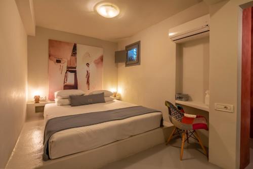 a bedroom with a bed and a desk and a chair at 270 Oias View in Oia