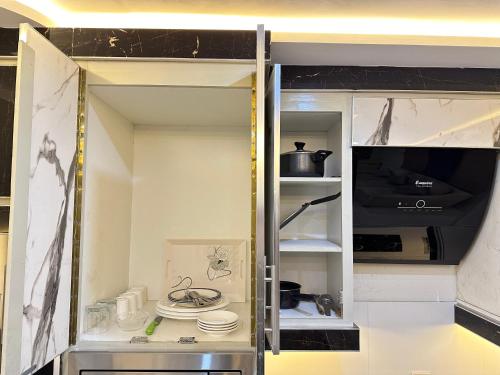 an open refrigerator with plates and a tv in it at Mukhtar Homes Bahria Town Lahore in Lahore