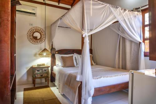 a bedroom with a bed with a canopy at Pousada Campestre in Trancoso