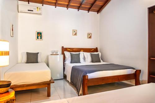 a bedroom with two beds and a bench in it at Pousada Campestre in Trancoso