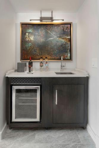 a kitchen with a sink and a painting on the wall at JW Marriott Savannah Plant Riverside District in Savannah