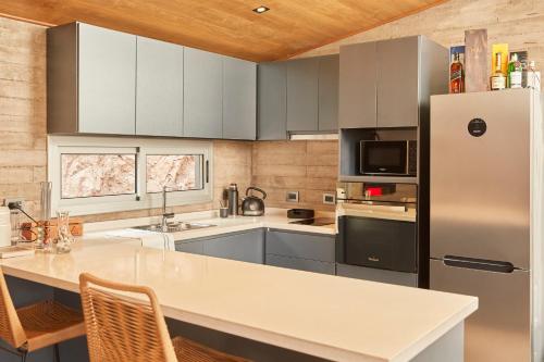a kitchen with a refrigerator and a white counter top at La Quebrada Potrerillos - Lodges de Montaña in Potrerillos