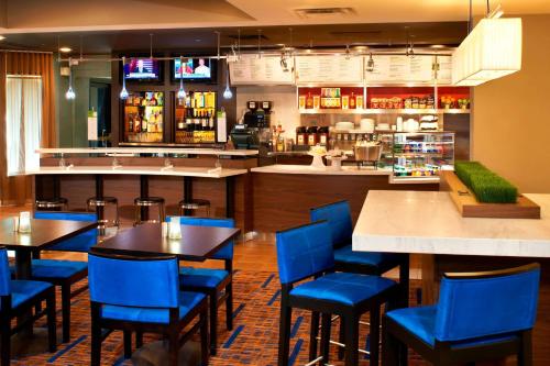a restaurant with blue chairs and tables and a bar at Courtyard by Marriott Cleveland Westlake in Westlake