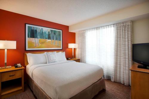 a hotel room with a bed and a television at Residence Inn by Marriott Detroit / Novi in Novi