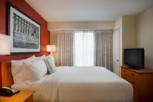 a hotel room with a bed and a television at Residence Inn by Marriott Detroit / Novi in Novi