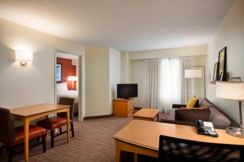 a hotel room with a living room with a bed and a room at Residence Inn by Marriott Detroit / Novi in Novi