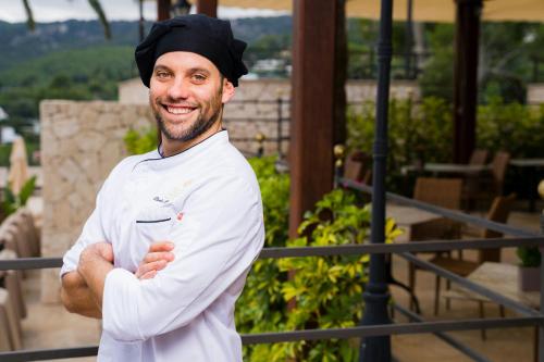 a man in a chefs outfit standing with his arms crossed at Castillo Hotel Son Vida, a Luxury Collection Hotel, Mallorca in Palma de Mallorca