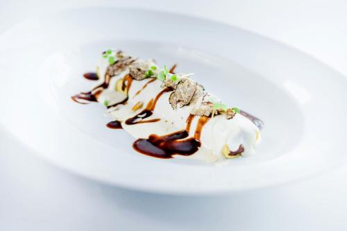 a dessert on a white plate on a table at Castillo Hotel Son Vida, a Luxury Collection Hotel, Mallorca in Palma de Mallorca