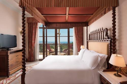 a bedroom with a canopy bed and a television at Castillo Hotel Son Vida, a Luxury Collection Hotel, Mallorca in Palma de Mallorca