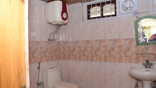 a bathroom with a toilet and a sink at valley view chalet in Bajaura