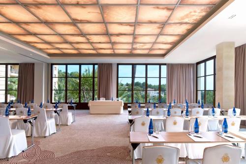a banquet hall with tables and chairs and windows at Castillo Hotel Son Vida, a Luxury Collection Hotel, Mallorca in Palma de Mallorca