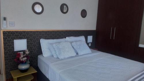 a bedroom with a bed with white sheets and pillows at Trojuan Inn Phakalane Surbab, Gaborone in Kgaphamadi