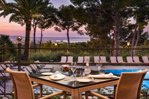 a table with wine glasses on a patio at Castillo Hotel Son Vida, a Luxury Collection Hotel, Mallorca in Palma de Mallorca