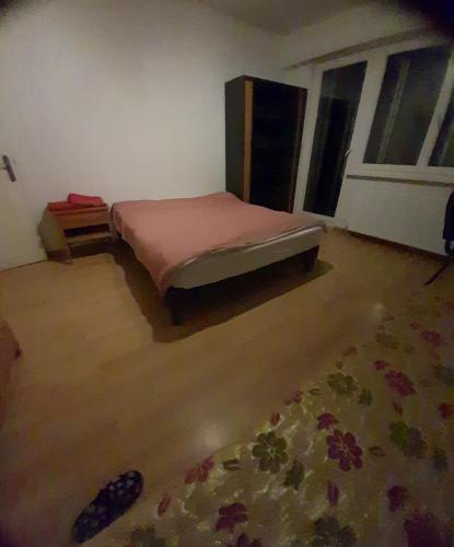 a bedroom with a bed in the corner of a room at family in Schiltigheim