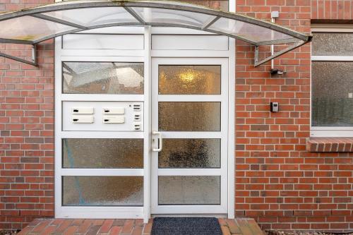 a white door with glass panels on a brick building at Apartment in Uni- und Citynähe in Oldenburg