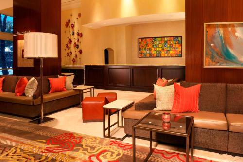 a living room with two couches and a table at Houston Marriott Sugar Land in Sugar Land