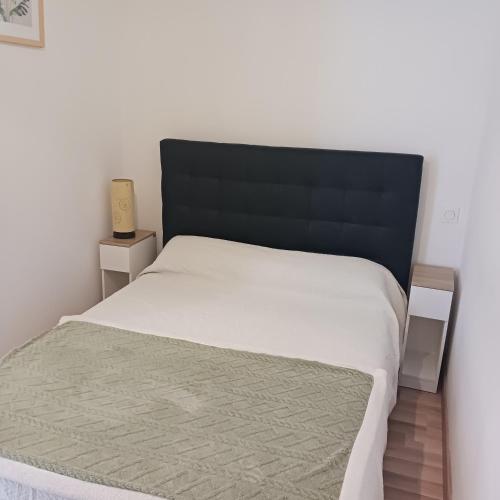 - un lit avec une tête de lit noire dans une chambre dans l'établissement Residence du parc, à Luz-Saint-Sauveur